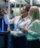 Two woman looking at a screen in a data center